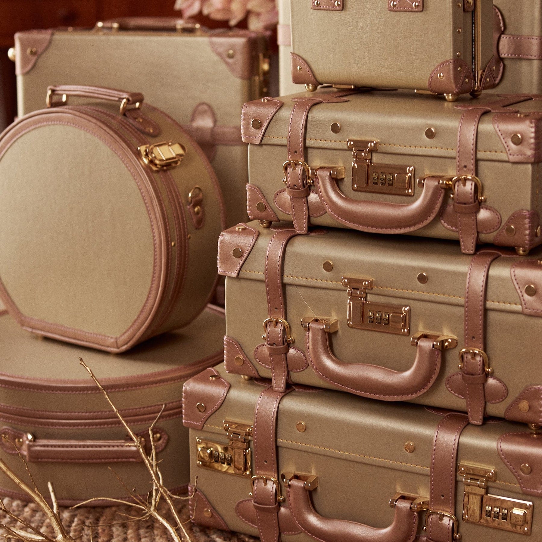 Lifestyle image of The Alchemist vegan leather suitcases in gold