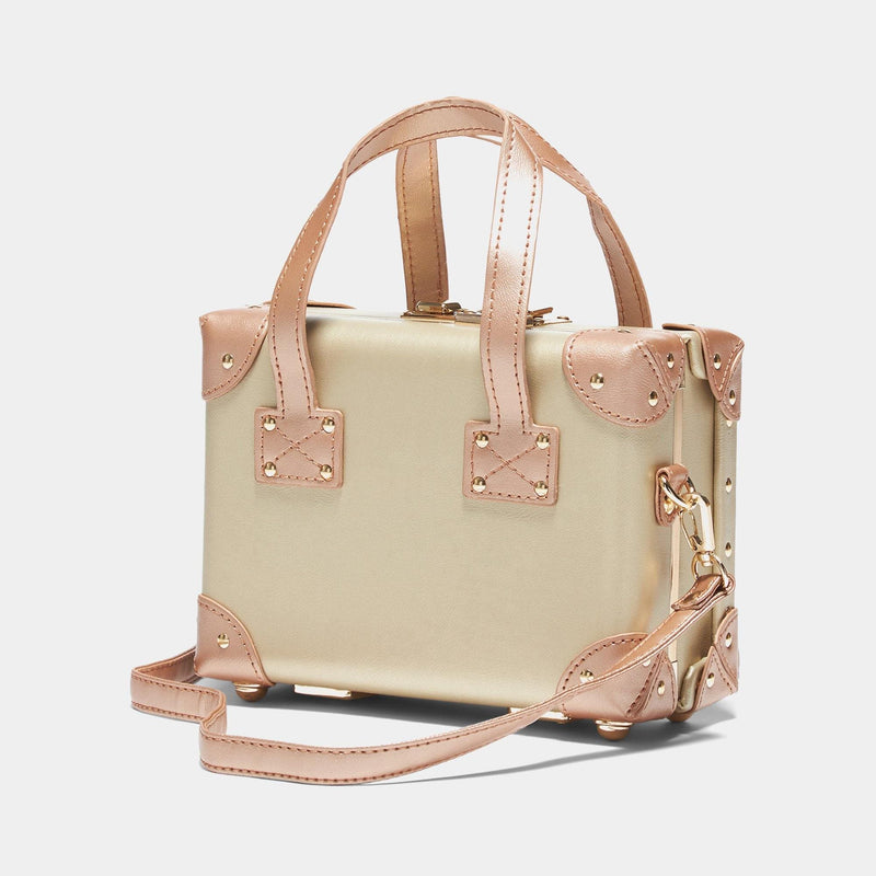 Angled product view of the mini Alchemist vegan leather suitcase in gold with shoulder attachment strap
