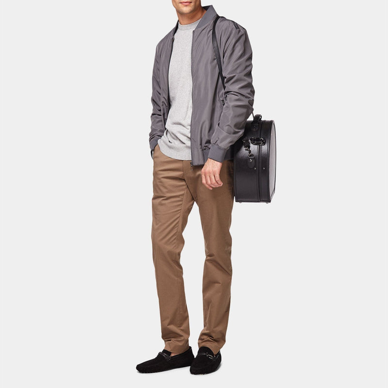 Model with the large hatbox Industrialist fibreboard suitcase in black with shoulder attachment strap