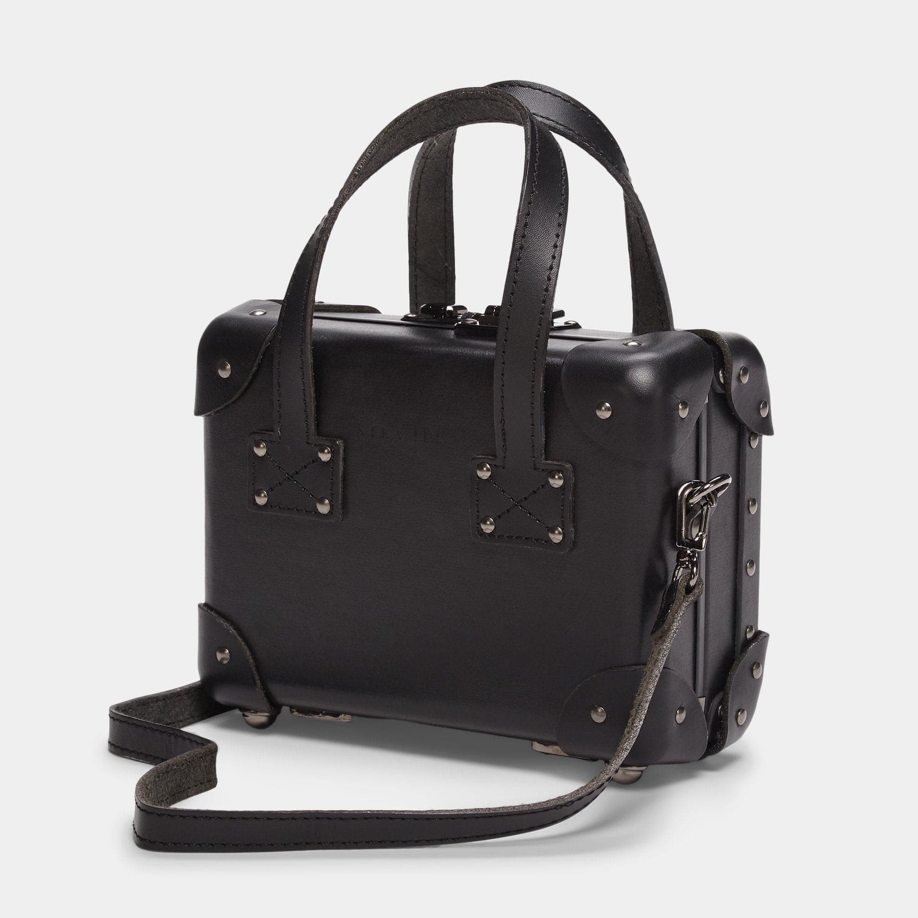 Angled product view of the mini Industrialist fibreboard suitcase in black with shoulder attachment strap