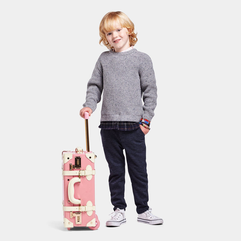 Kid model with the carry-on Entrepreneur vegan leather suitcase in pink with raised handle