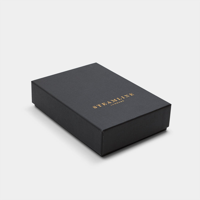 Image of The Navigator passport holder packaging in black with desert glitter Steamline logo