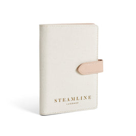 Angled view of the Navigator leather passport holder in white with stone trim and logo