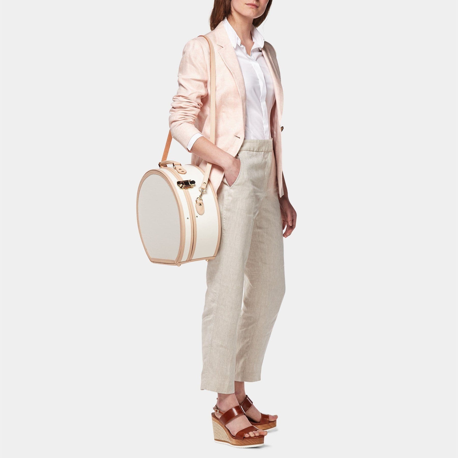 Model with the large hatbox Sweetheart fibreboard suitcase in cream with shoulder attachment strap