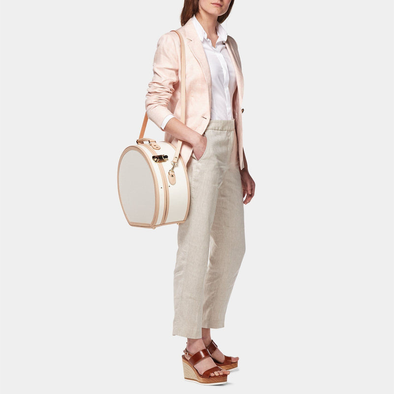 Model with the large hatbox Sweetheart fibreboard suitcase in cream with shoulder attachment strap