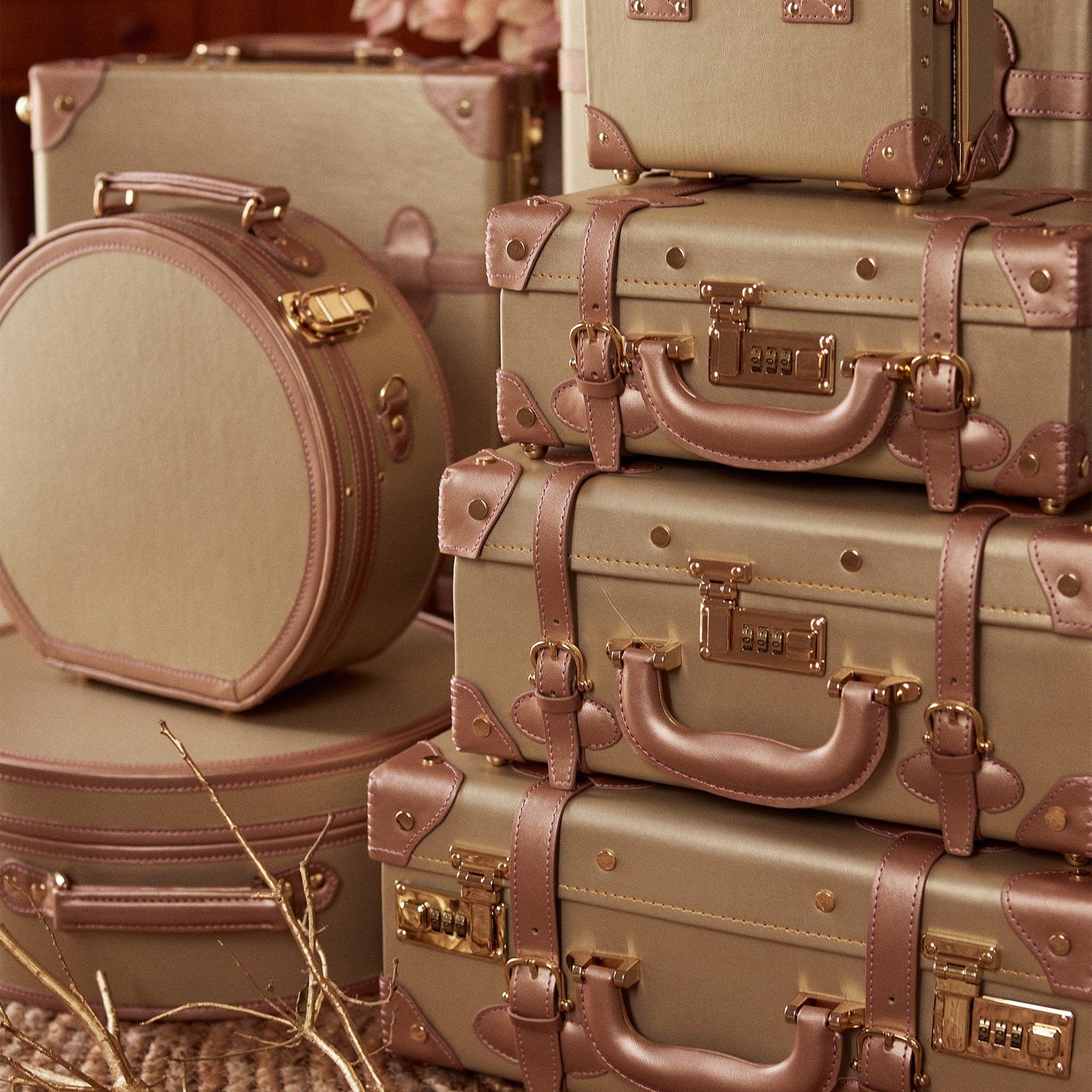 Lifestyle image of The Alchemist vegan leather suitcases in gold 