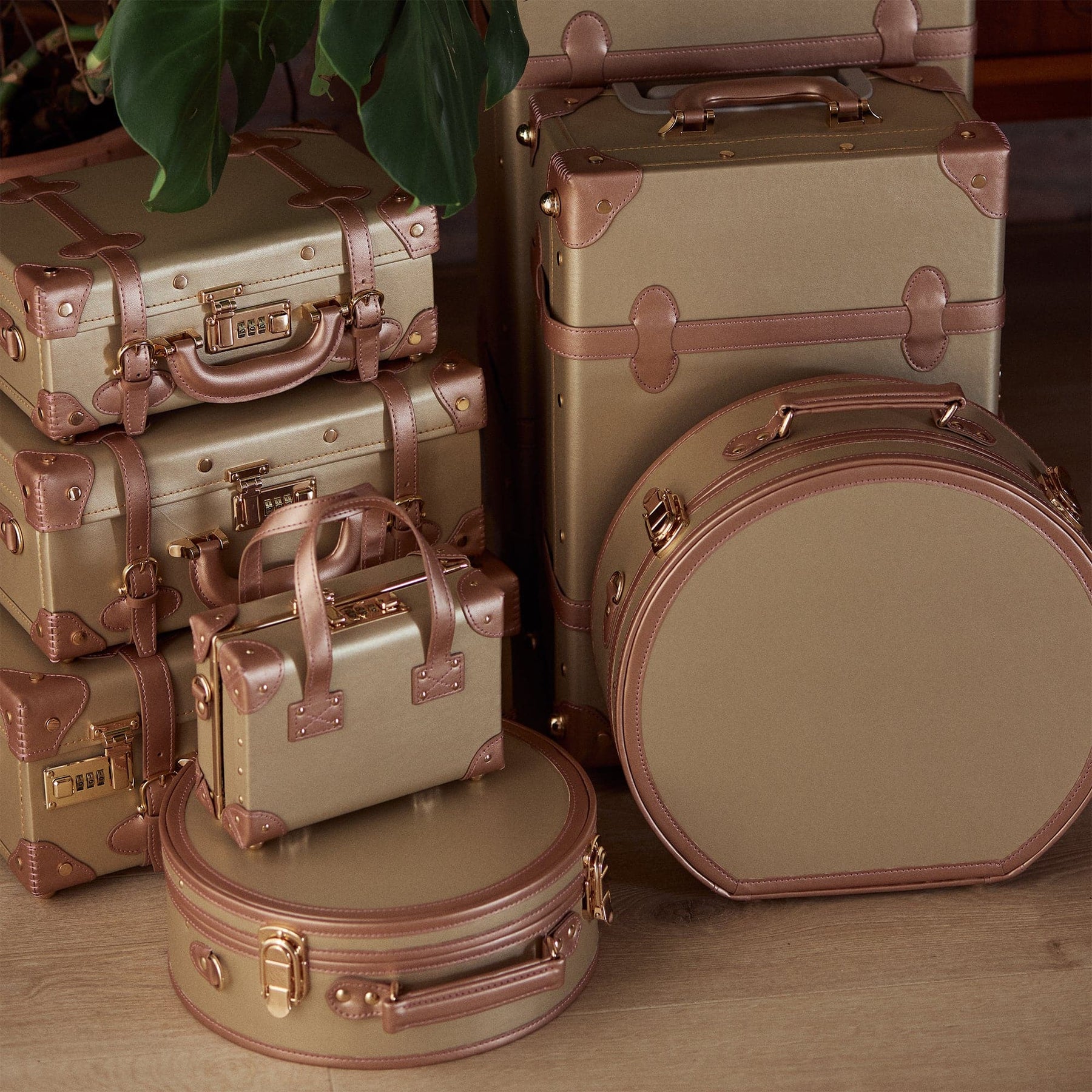 Lifestyle image ofThe Alchemist vegan leather suitcases in gold