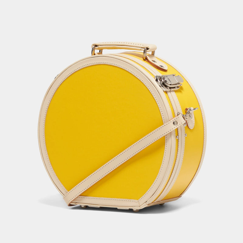 Angled product view of the small hatbox Correspondent fibreboard suitcase in canary yellow with detachable shoulder strap