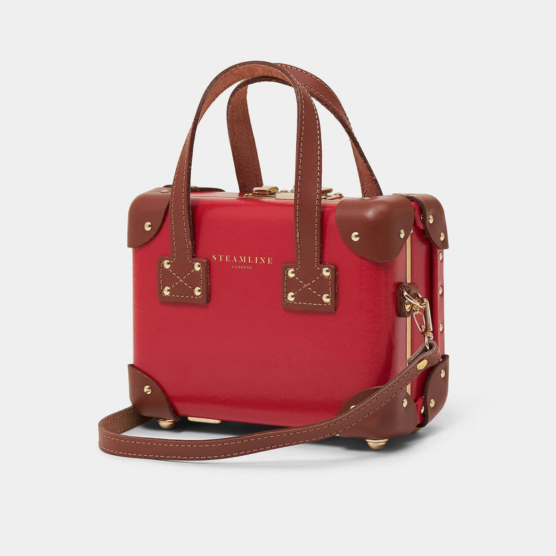 Angled product view of the mini Diplomat leather suitcase in red with shoulder attachment strap