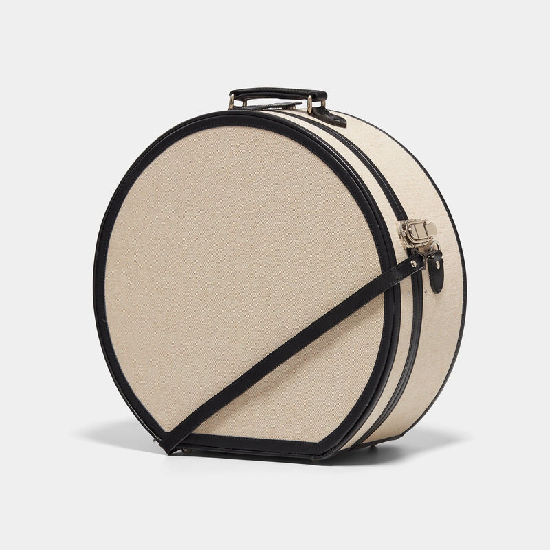 Angled product view of the deluxe hatbox Editor linen suitcase with black trims and shoulder attachment strap