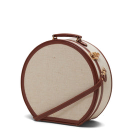 Angled product view of the large hatbox Editor linen suitcase with brown trims and shoulder attachment strap