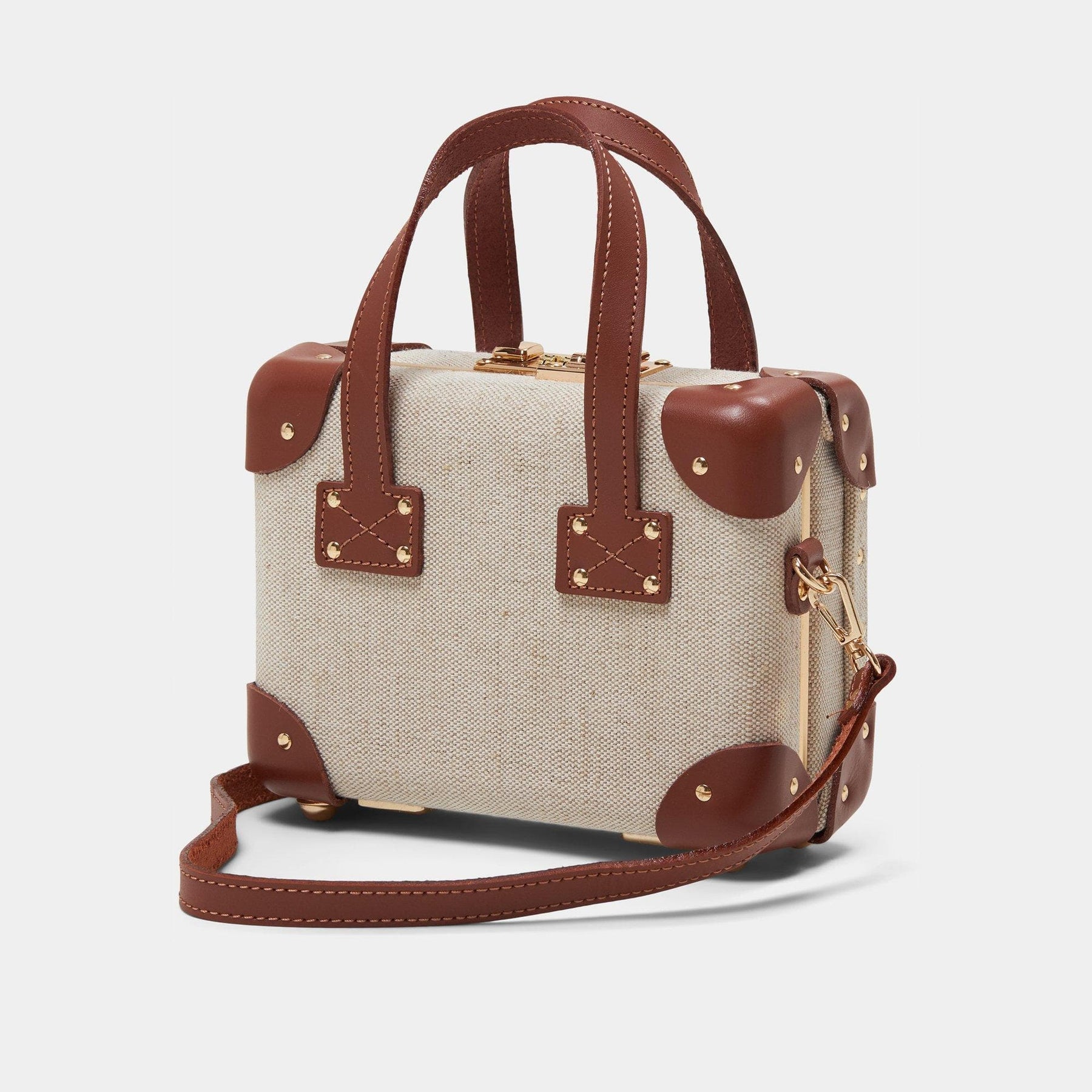 Angled product view of the mini Editor linen suitcase with brown trims and shoulder attachment strap