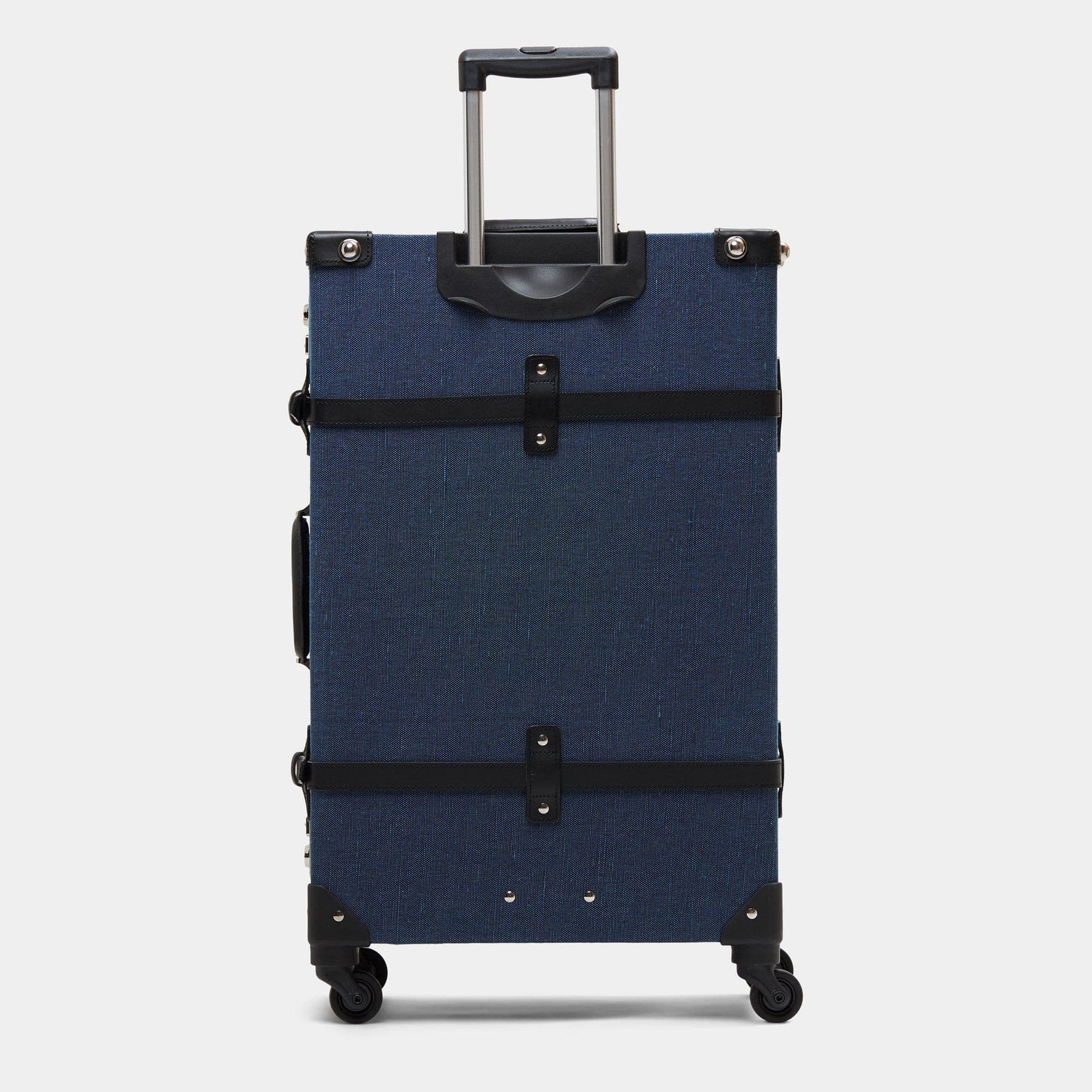 Back product view of the check-in spinner Editor linen suitcase with navy body, black trims and raised handle