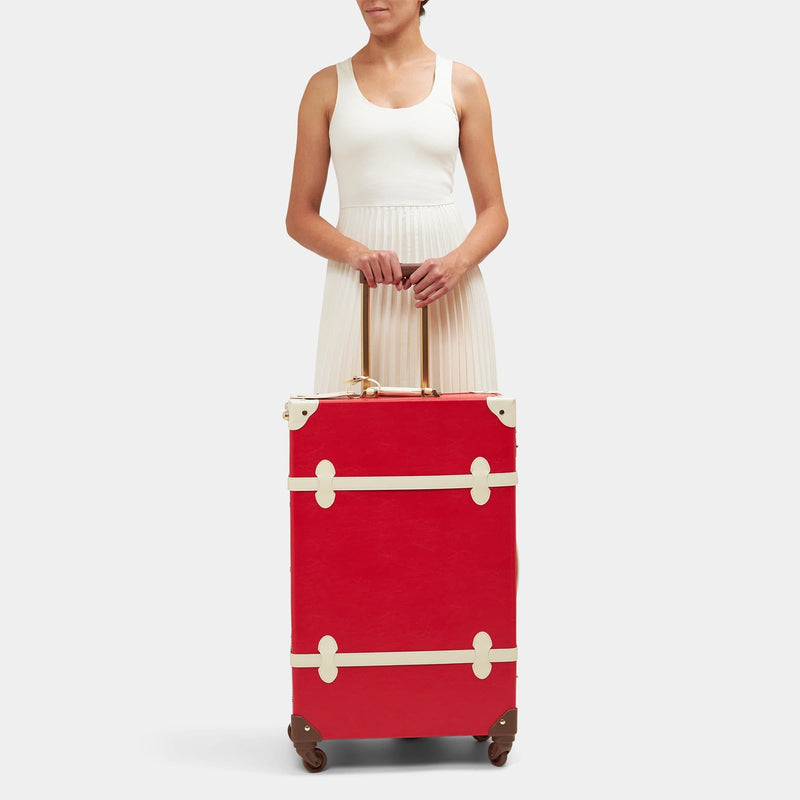 Model with the check-in spinner Entrepreneur vegan leather suitcase in lipstick red 