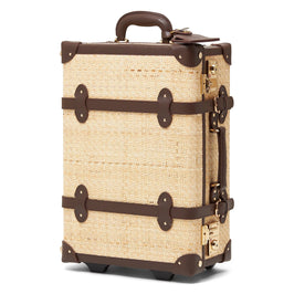 Angled product view of the carry-on Explorer rattan suitcase in natural wicker body and brown trims 