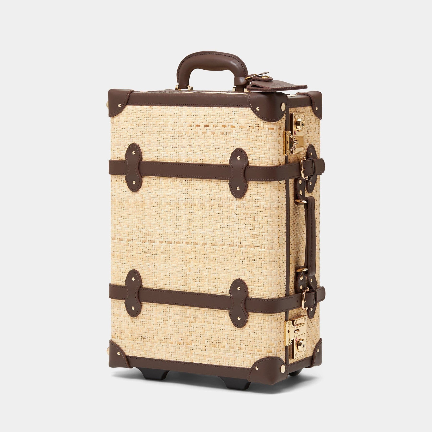 Angled product view of the carry-on Explorer rattan suitcase in natural wicker body and brown trims 