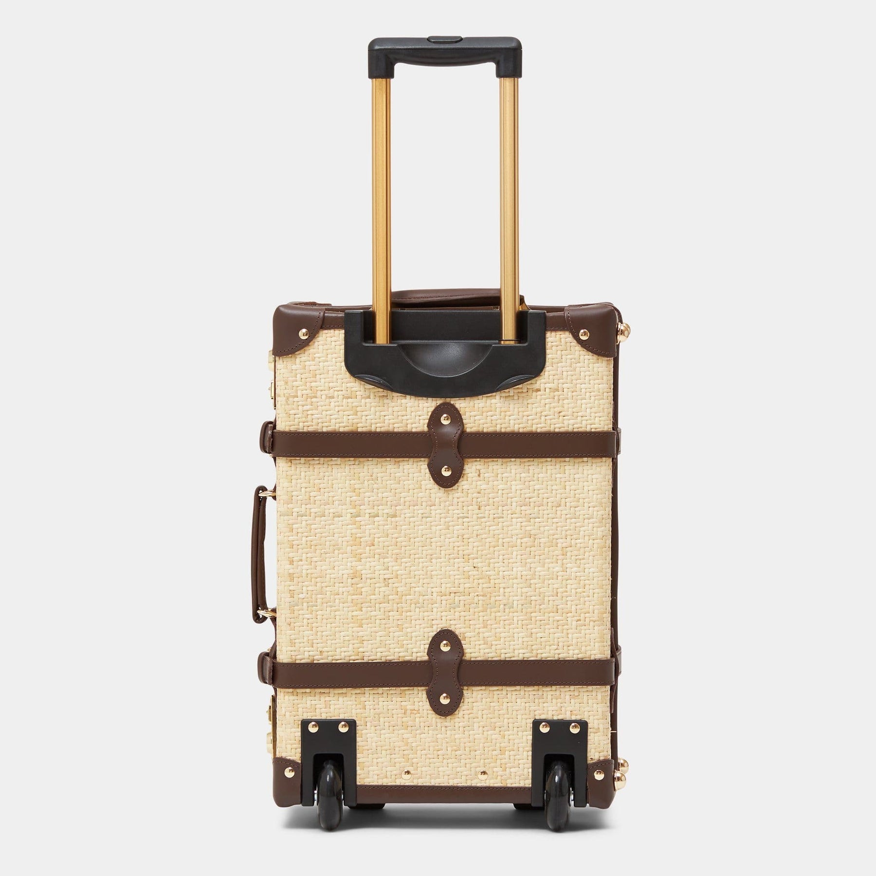 Back product view of the carry-on Explorer rattan suitcase in natural wicker body and brown trims with raised handle