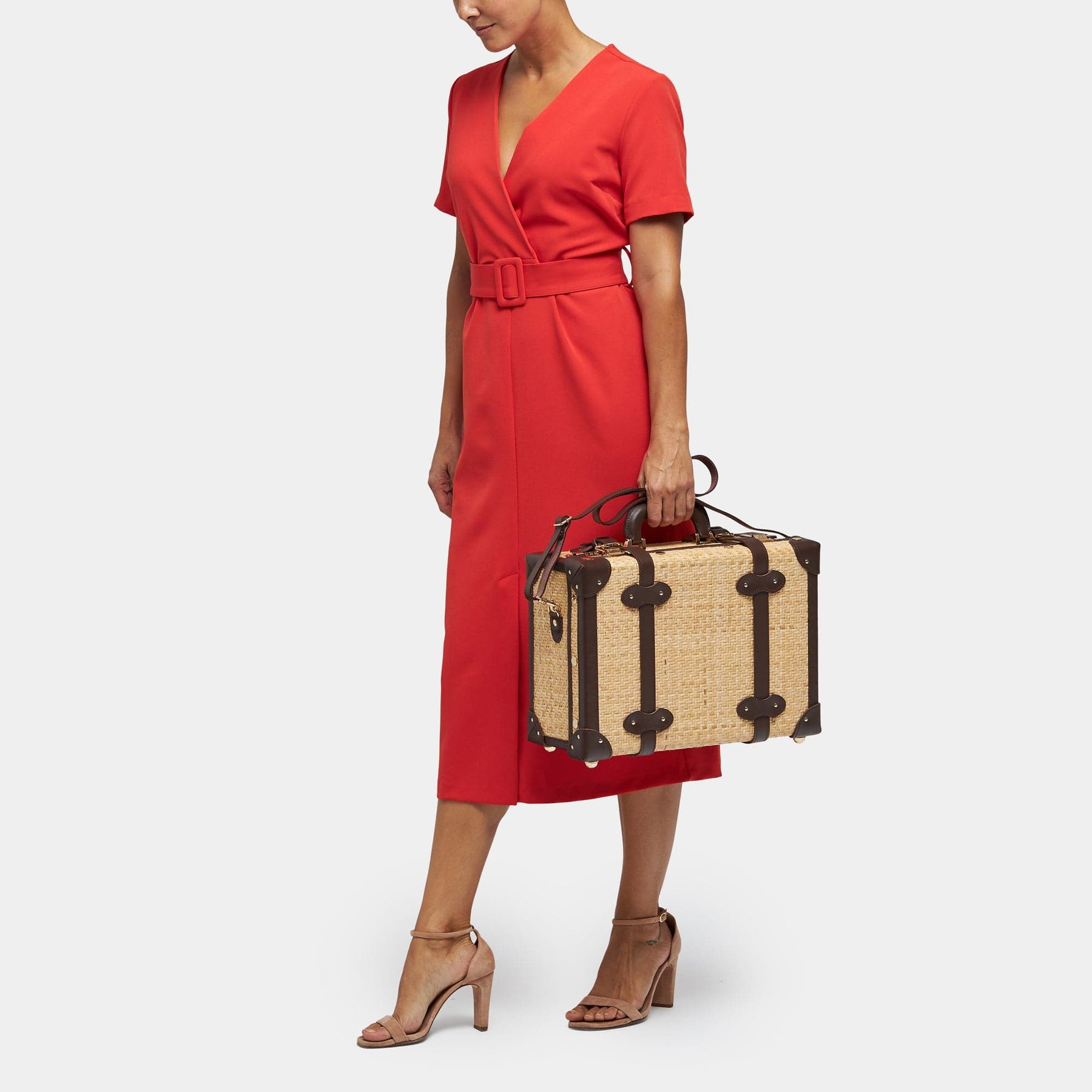 Model with the overnighter Explorer rattan suitcase in natural wicker body and brown trims with shoulder attachment strap