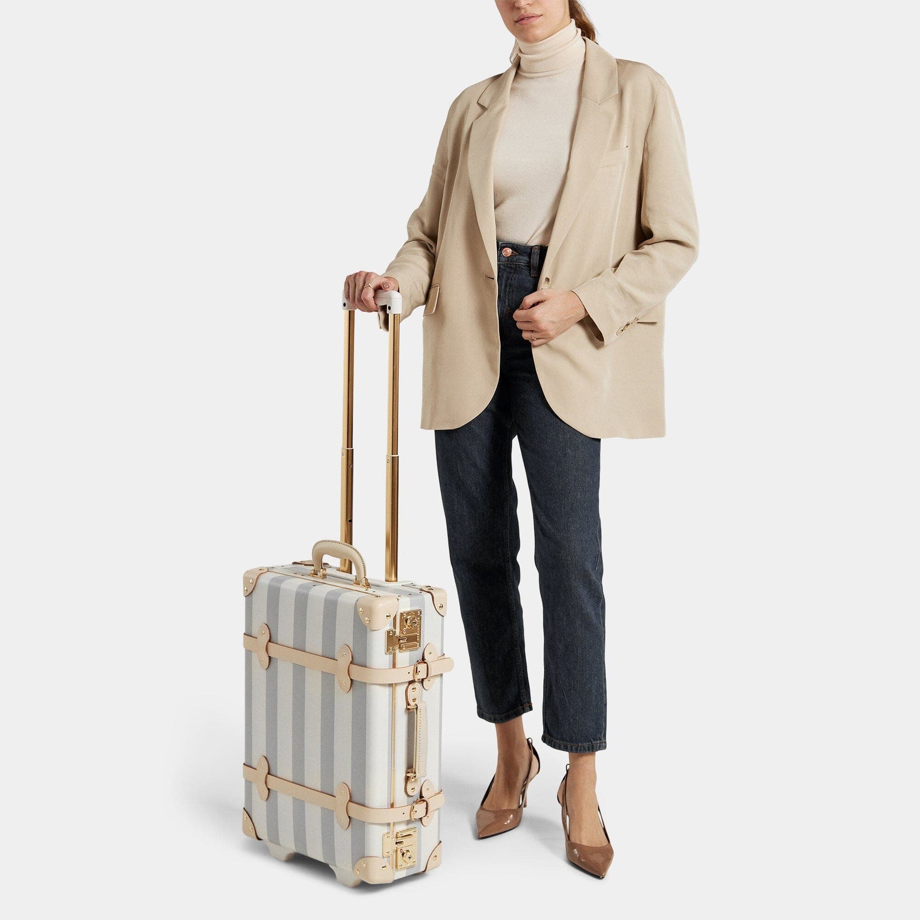 Model with the carry-on Illustrator fibreboard suitcase in blue-stripe with raised handle