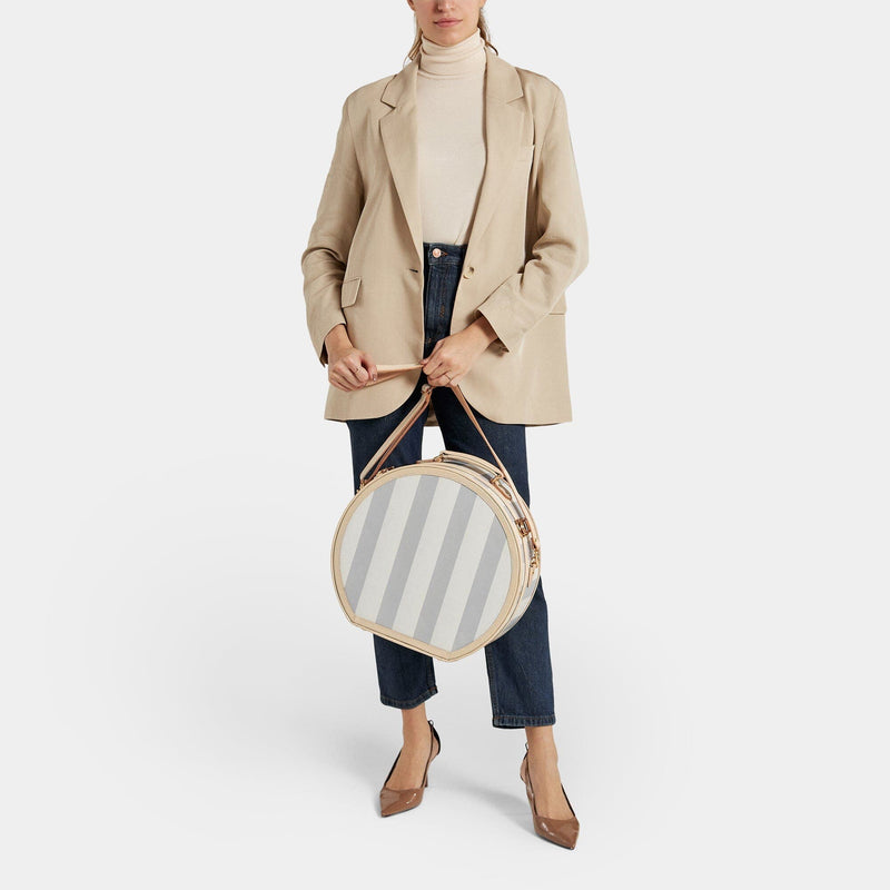 Model with the large hatbox Illustrator fibreboard suitcase in blue-stripe with shoulder attachment strap