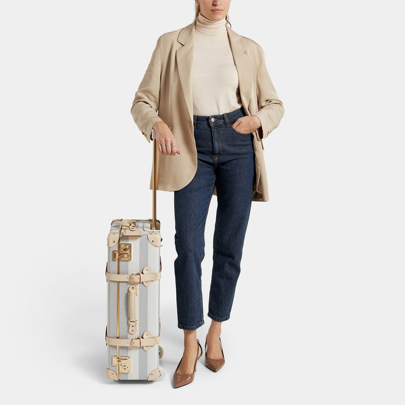 Model with the stowaway Illustrator fibreboard suitcase in stripe blue with raised handle