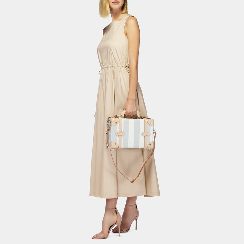 Model with the vanity Illustrator fibreboard suitcase in blue-stripe with shoulder attachment strap