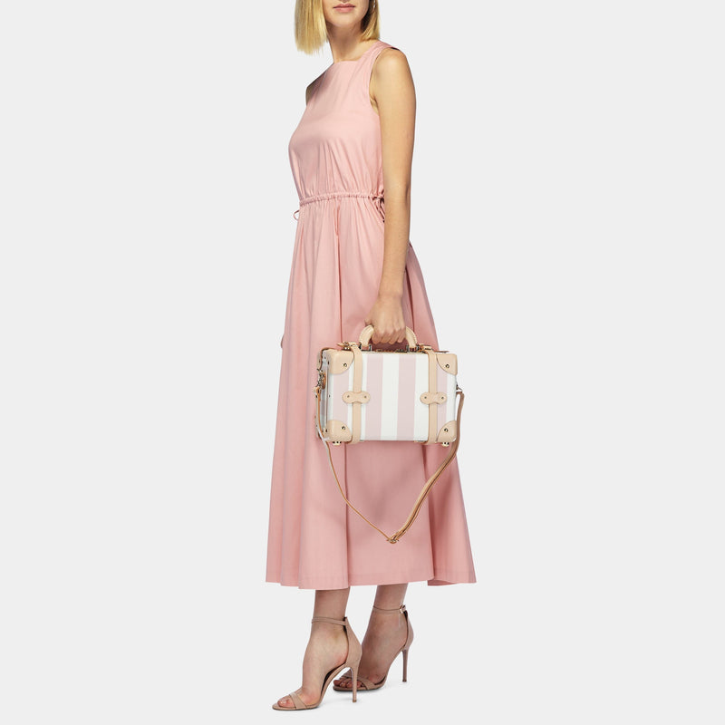 Model with the mini Illustrator fibreboard suitcase in pink-stripe with shoulder attachment strap