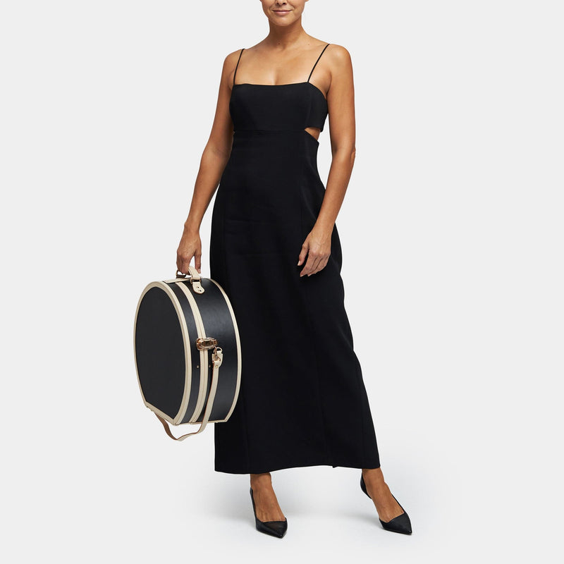 Model  with the deluxe hatbox Starlet fibreboard suitcase in black with shoulder attachment strap