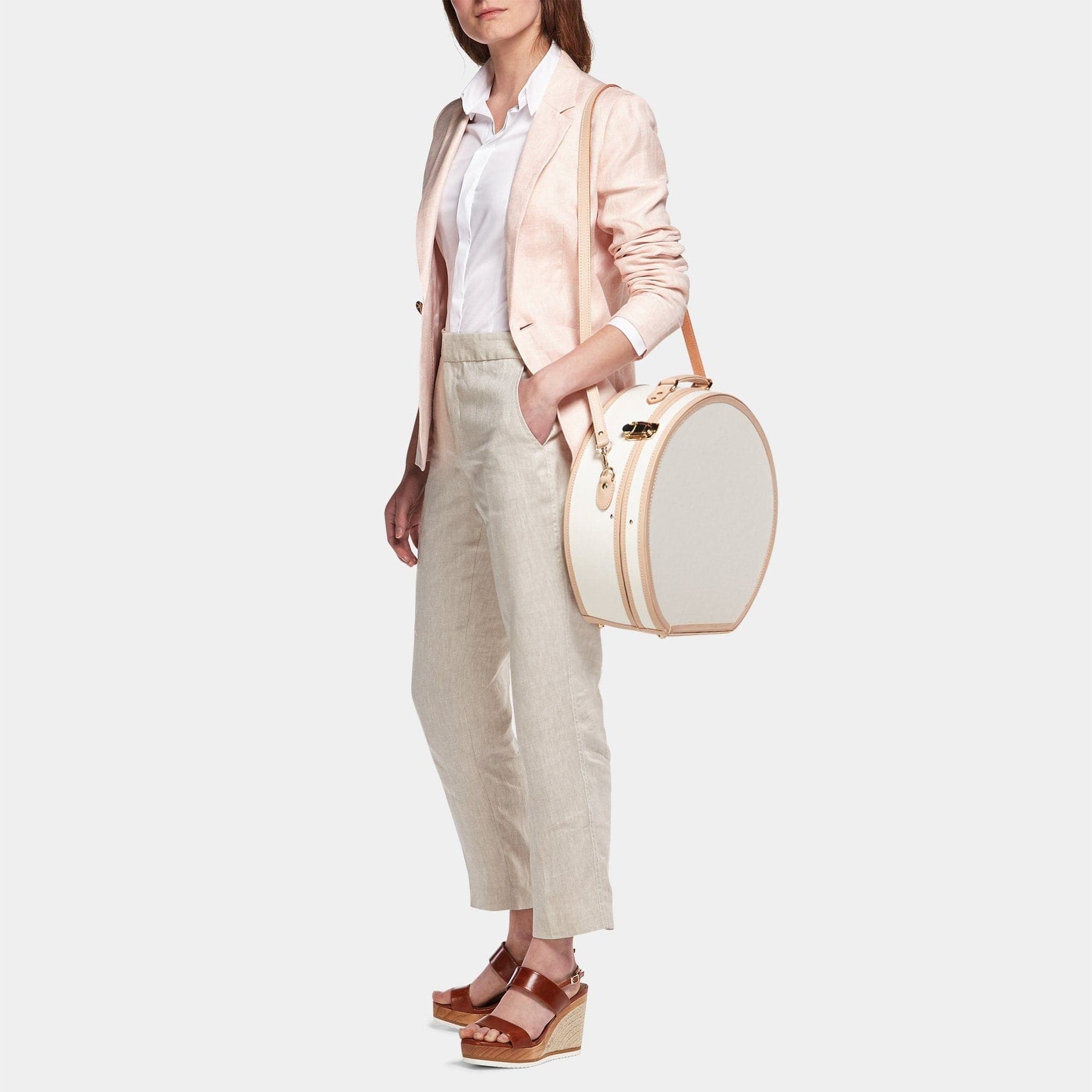 Model  with the deluxe hatbox Sweetheart fibreboard suitcase in cream with shoulder attachment strap