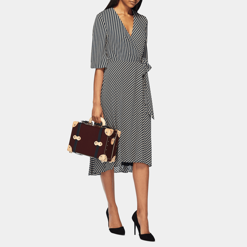 Model with the vanity Architect leather suitcase in burgundy