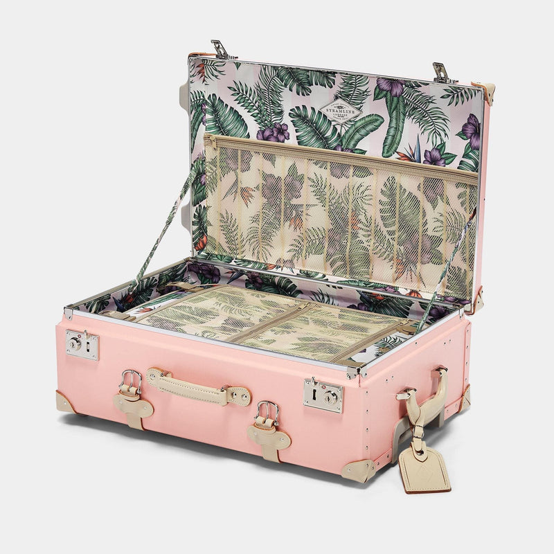 Open product view of the check-in Botanist fibreboard suitcase in pink with palm & flower printed lining and ivory leather luggage tag
