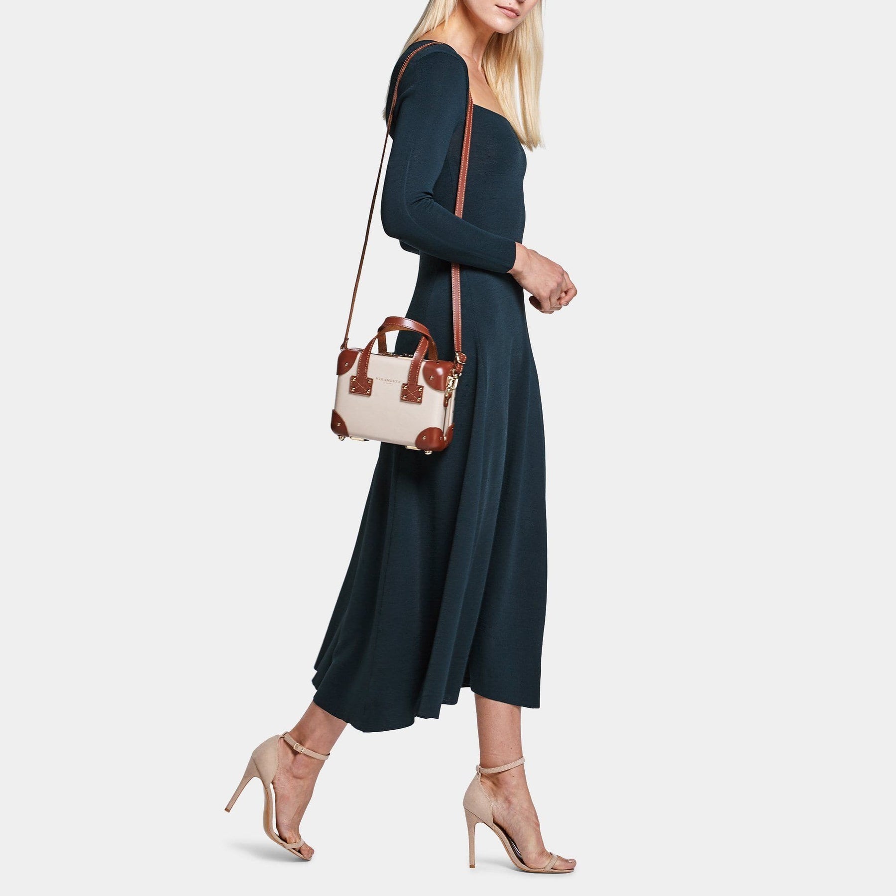 Model with the mini Diplomat leather suitcase in cream with shoulder attachment strap