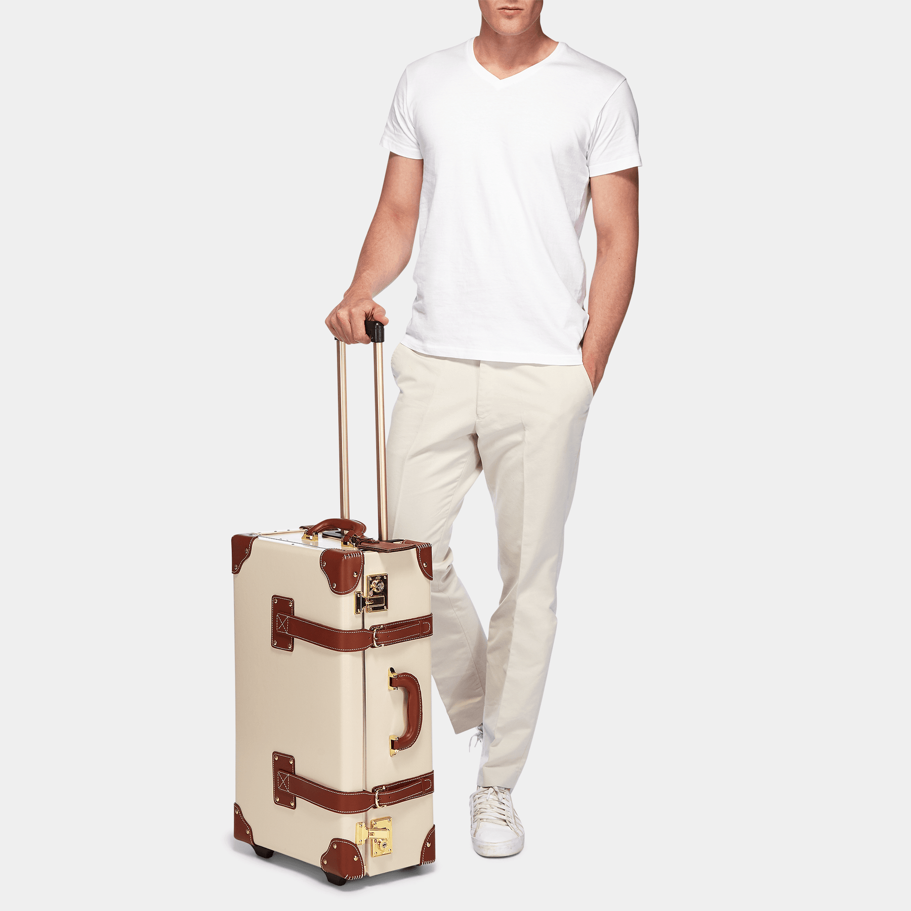Male model with the stowaway Diplomat leather suitcase in cream with raised handle
