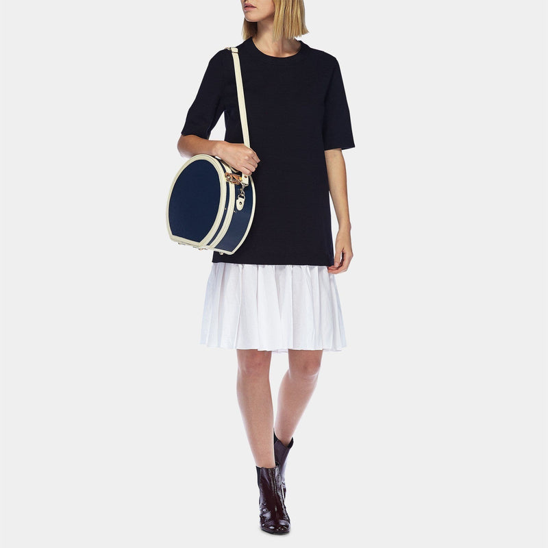Model with the small hatbox Entrepreneur vegan leather suitcase in navy with shoulder attachment strap