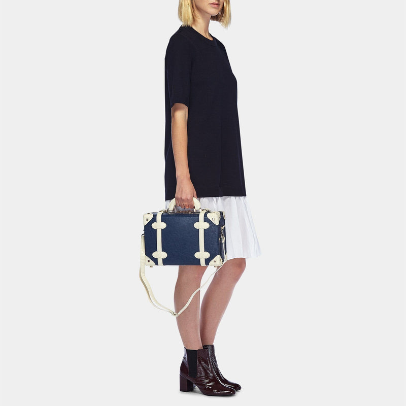 Model with the vanity Entrepreneur vegan leather suitcase in navy with shoulder attachment strap