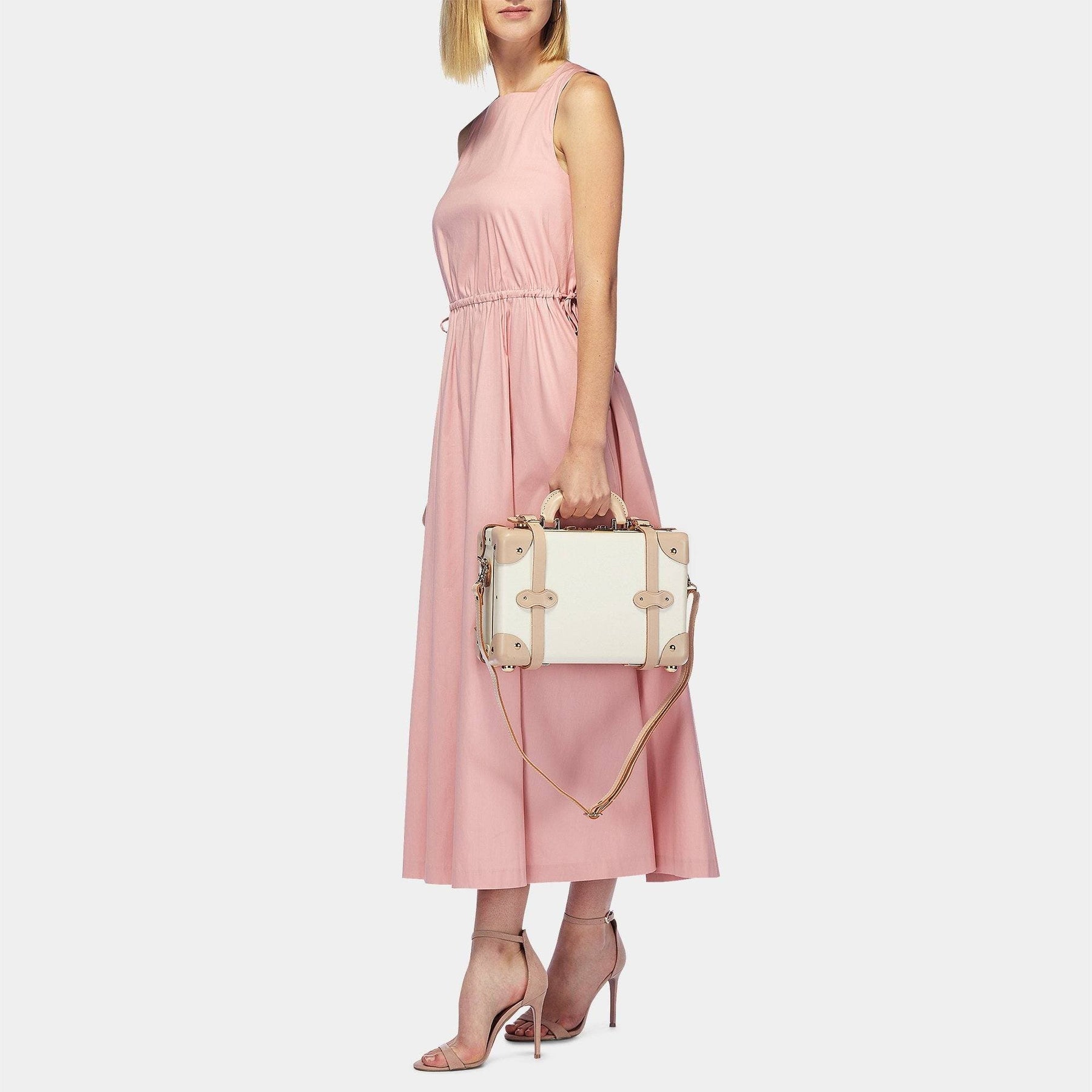 Model with the vanity Sweetheart fibreboard suitcase in cream with shoulder attachment strap