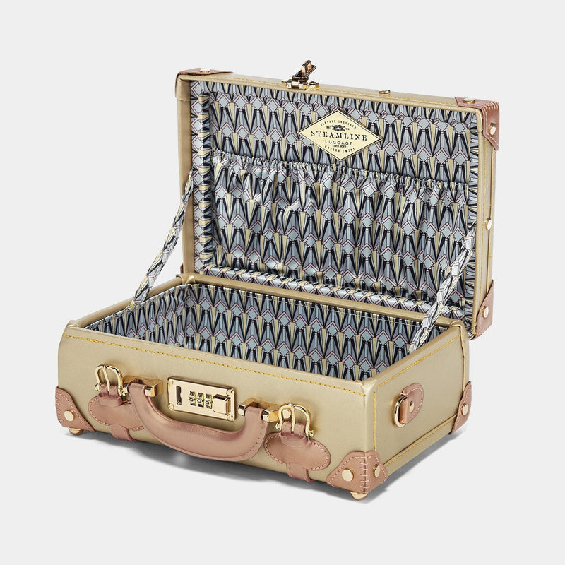 Open product view of the vanity Alchemist vegan leather suitcase in gold with art-deco print lining