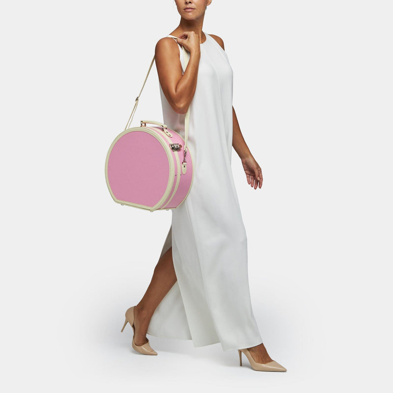 Model with the large hatbox Entrepreneur vegan leather suitcase in pink with shoulder attachment strap