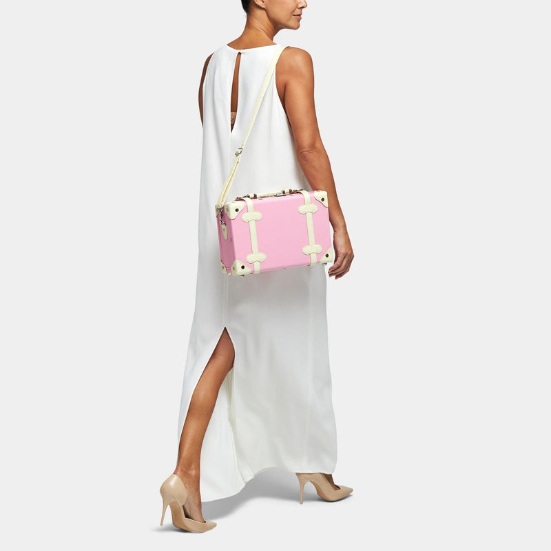 Model with the vanity Entrepreneur vegan leather suitcase in pink with shoulder attachment strap